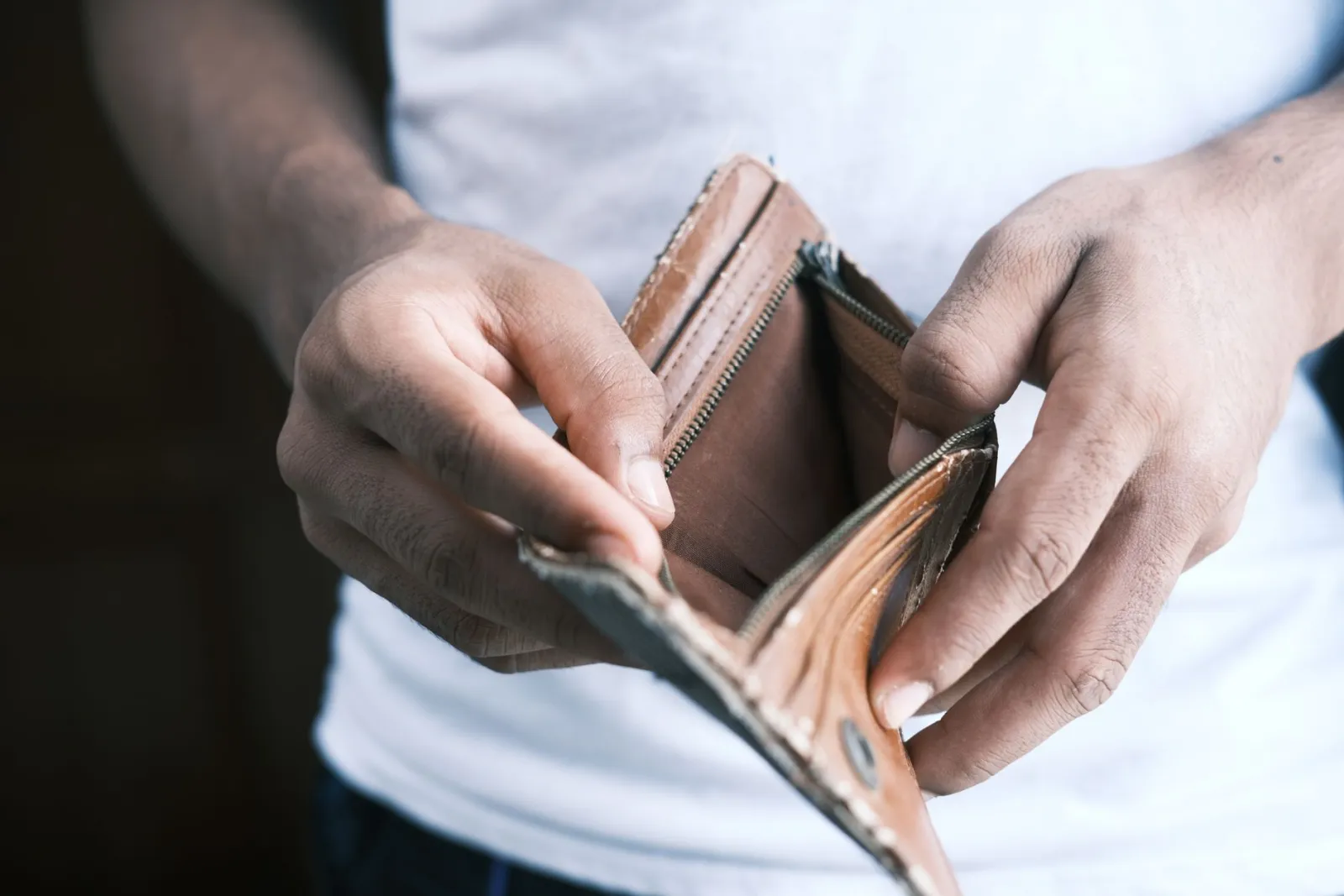 Hands opening an empty leather wallet