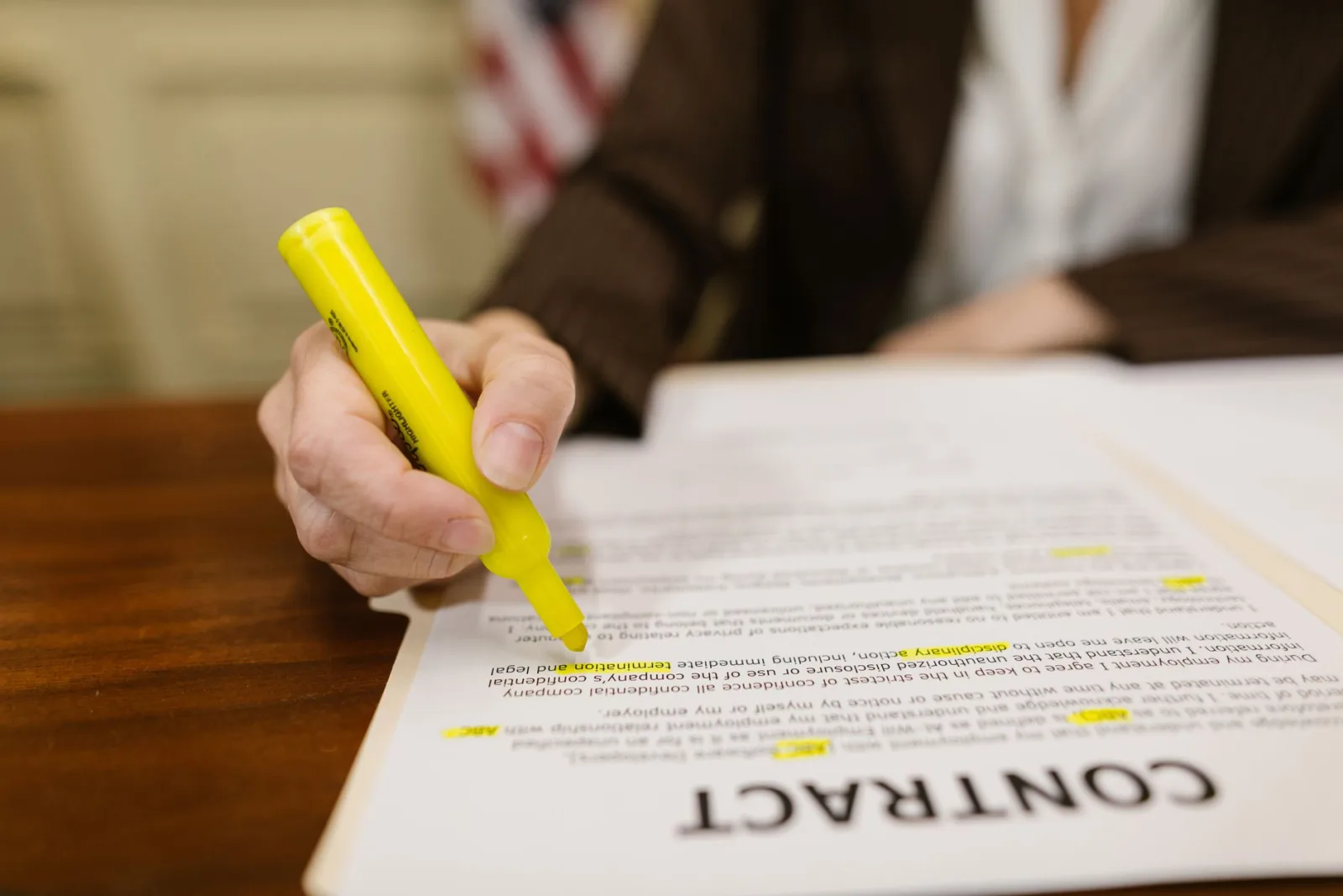 Hand marking errors on a printed document with a yellow highlighter