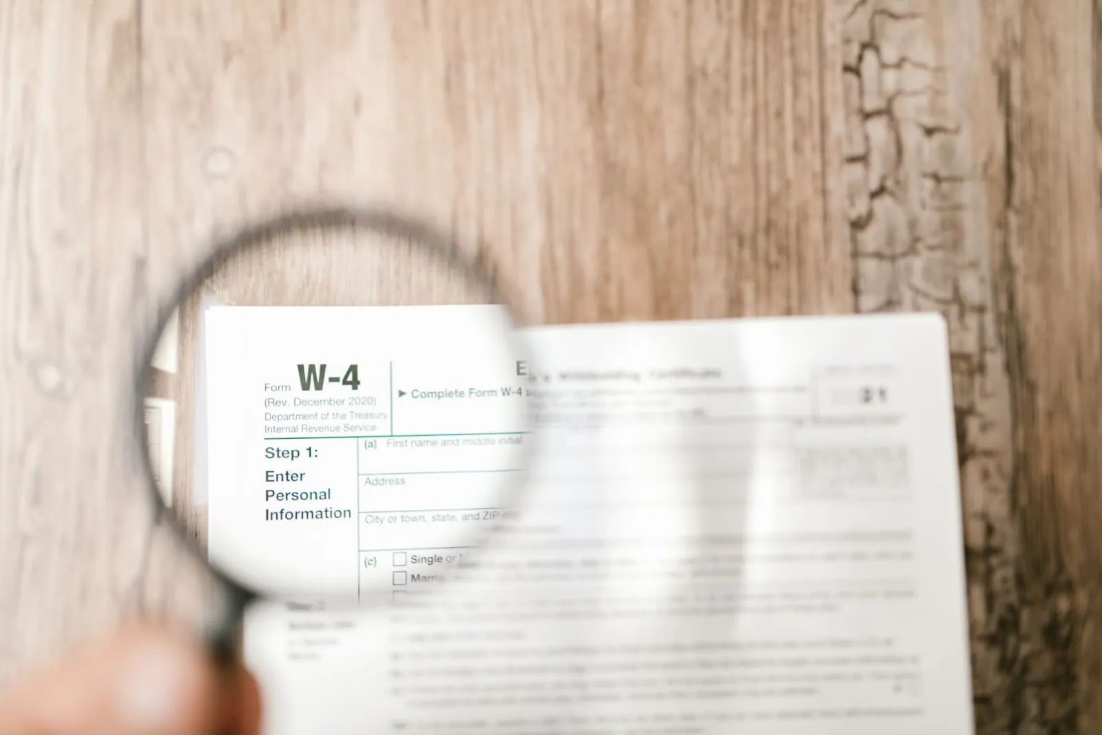 Magnifying glass held over a printed tax form, reading every line