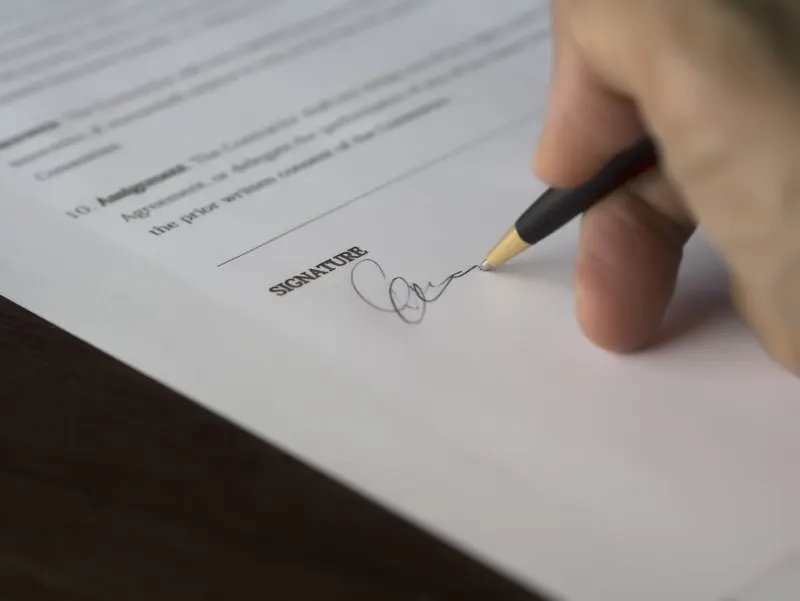 Close-up of a pen signing the signature line of a sworn statement