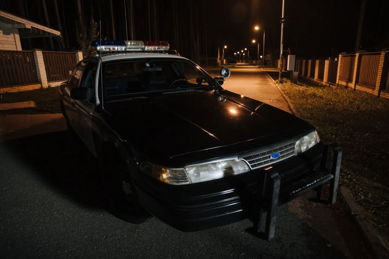 Police cruiser parked on a dark street at night